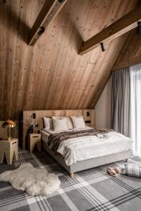 扎科帕内Owce Dwie的一间卧室设有一张大床和木制天花板。
