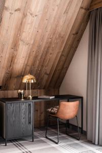扎科帕内Owce Dwie的木制天花板的客房内配有一张桌子和一把椅子