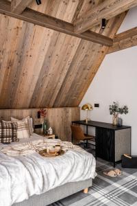 扎科帕内Owce Dwie的卧室设有木制天花板、一张床和一张书桌
