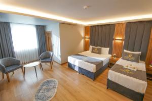 ArnavutköyElite Port Hotel的酒店客房带两张床和一张桌子以及椅子。