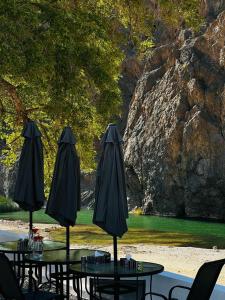 马斯喀特Wadi Al Arbeieen Resort的庭院里一组桌子和遮阳伞