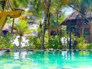 坦加拉The Alpha Monkey hotel & Tree house的棕榈树度假村前的游泳池