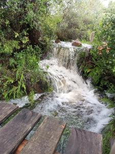 米纳斯Casa de campo la serena的小溪前的瀑布,带木凳