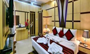 穆扎夫法尔普尔FabHotel Prime Simna International的一间卧室配有一张带红色枕头的大床