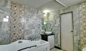 穆扎夫法尔普尔FabHotel Prime Simna International的浴室配有白色浴缸和水槽