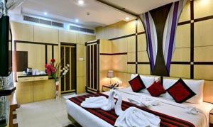 穆扎夫法尔普尔FabHotel Prime Simna International的卧室配有带红色枕头的大型白色床