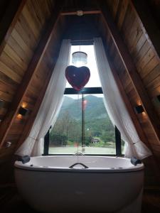 大普拉亚Vista dos Canyons的阁楼上设有浴缸的心形窗户
