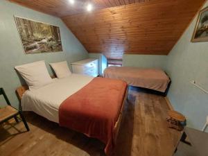 拉罗什-阿登Le Vieux La Roche的一间卧室设有两张床和木制天花板