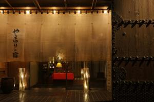 花卷市山百合日式旅馆的一间设有桌子、红色长凳和灯的房间
