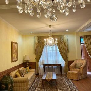 万隆Casa Setra Bandung的客厅配有沙发、椅子和吊灯