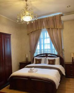 万隆Casa Setra Bandung的一间卧室配有一张大床、吊灯和窗户