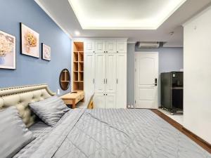 胡志明市Golden Sun Hotel Apartments的一间卧室配有一张带蓝色墙壁的大床