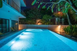 皮皮岛皮皮岛通塞酒店的夜间在房子里的一个游泳池