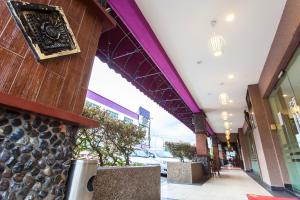 新山Lavender Inn Nusa Bestari的一座带紫色天花板和走道的建筑