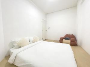 Thung Si KanTRANSIT Donmueang Airport HOSTEL的白色卧室配有一张大床和泰迪熊