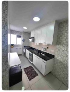 圣保罗Apartamento em Moema的厨房配有白色橱柜和黑色台面