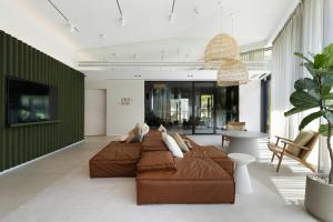 格但斯克Elite Apartments Brzeźno Premium的客厅设有2张棕色沙发和1面绿色的墙壁
