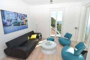 萨斯尼茨Ostseeresidenz Sassnitz F548 Penthouse 20 mit Sauna, Balkon, Meerblick的客厅配有黑色沙发和蓝色椅子
