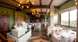 Bergondo博斯酒店的餐厅设有白色的桌椅和窗户。