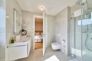 玛丽亚韦尔特Hermitage Vital Hotel的带淋浴、盥洗盆和卫生间的浴室