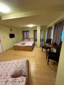 奥赫里德Casa Norvegia Ohrid的一间卧室配有两张床、一张桌子和一张沙发