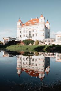 Wojanów帕拉斯沃间诺酒店的一座大型的白色城堡,其反射在水中