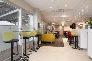 亚眠快捷假日阿米安酒店的一间设有黄色和红色椅子的理发店