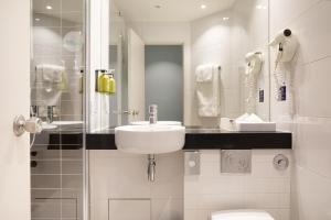 亚眠快捷假日阿米安酒店的白色的浴室设有水槽和卫生间。