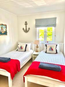 南塞尔尼Spinnaker Lodge · Cotswolds Lakeside Home的一间卧室设有两张床和窗户。