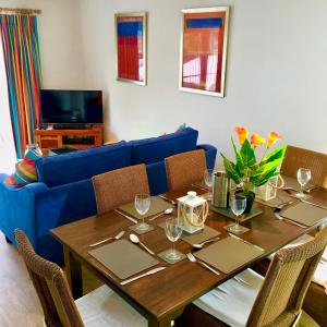 南塞尔尼Spinnaker Lodge · Cotswolds Lakeside Home的客厅配有桌子和蓝色沙发