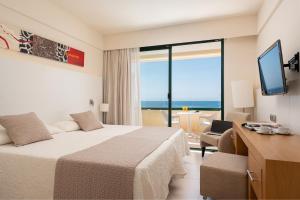 萨科马Welikehotel Marfil Playa的酒店客房设有一张床,享有海景。