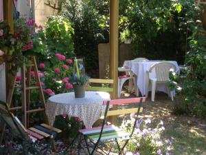 默兹河畔凡尔登Chambres D'Hôtes Des 3 Rois的花园配有桌椅和鲜花