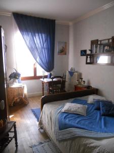 默兹河畔凡尔登Chambres D'Hôtes Des 3 Rois的一间卧室设有蓝色的床和窗户。
