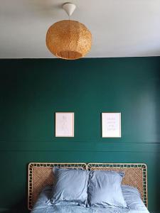 瑟堡Maison de ville quartier Pasteur的一间卧室设有绿色的墙壁和一张带枕头的床