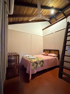 希门尼斯港Cabinas Tropicales的一间卧室配有一张床和吊扇