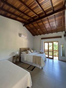 伊利亚贝拉La Bella Suítes的一间卧室设有两张床和木制天花板