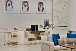 迪拜Hilton Dubai Palm Jumeirah的客厅配有白色家具和墙上的画像