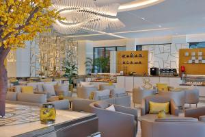 迪拜Hilton Dubai Palm Jumeirah的餐厅配有白色的桌椅和吊灯