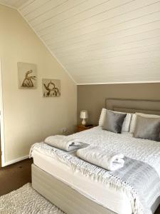 南塞尔尼Grange Lodge的一间卧室配有一张带白色床单的大床