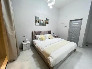 Badīyahalsaif camp的一间卧室配有带白色床单和黄色枕头的床。