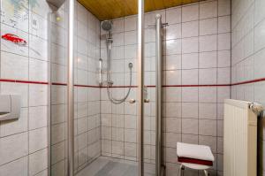 特里贝格Schwarzwald Nescht Triberg的浴室里设有玻璃门淋浴