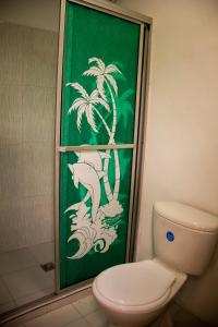 佩雷拉Coliving La Rebeca Pereira的一间带卫生间的浴室和棕榈树绿色墙壁