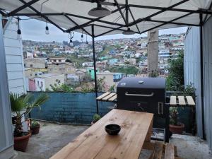 瓦尔帕莱索Cerca del Puerto y Plaza SotoMayor的露台上的木桌旁的烧烤架