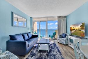 默特尔比奇Bay Watch Resort 1203 - Perfect Oceanside Getaway的客厅配有蓝色的沙发和电视