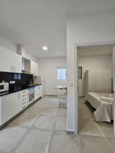 巴塞罗那Apartamentos La Meridian的白色的厨房配有床和桌子