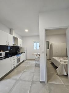 巴塞罗那Apartamentos La Meridian的白色的厨房配有床和桌子