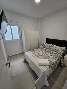 巴塞罗那Apartamentos La Meridian的白色的卧室设有床和窗户