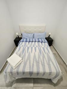 巴塞罗那Apartamentos La Meridian的一张带蓝色和白色条纹棉被的床