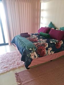 拉莫西17 Santana Pebbles Penthouse的一间卧室配有一张带花卉床罩的床