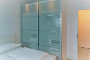 萨格勒布Špansko view -Comfy apartment的卧室内的玻璃柜,配有床